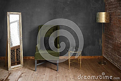 Dark green soft armchair near plaster wall Stock Photo