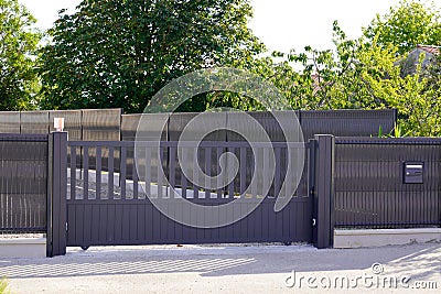 Dark grey gate aluminum portal with blades suburbs house street Stock Photo