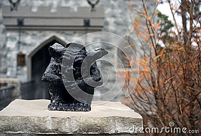 Small black gargoyle awaits unaware visitors Stock Photo