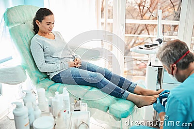 Beautiful woman patient on pedicure treatment with pediatrician chiropodist Stock Photo