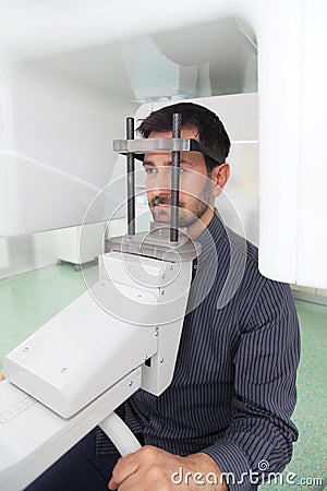 Dark hair man with beard waiting for an x-ray of his teeth. Stock Photo