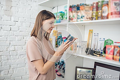 Dark-haired girl choosing nutriments for her pet in a pet store Stock Photo