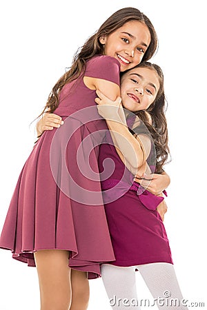 Dark-haired girl sisters in fashionable dresses Stock Photo