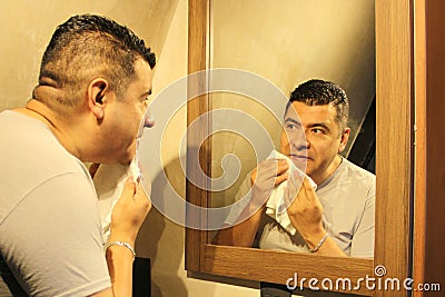 Dark-haired 40-year-old Latino man does his beauty routine, shaves with shaving cream and soap to avoid folliculitis Stock Photo