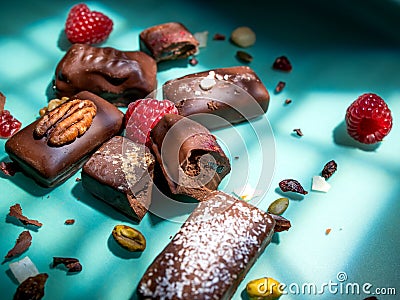 Dark handmade chocolate stack, coconut chips, raspberries and nuts Stock Photo