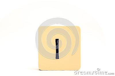 Dark letter I on a pale yellow square block isolated on white background Stock Photo