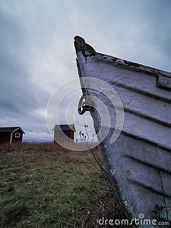 Dark mood with shipwreck in the foreground and old Sweden houses in front of the water in the background Stock Photo