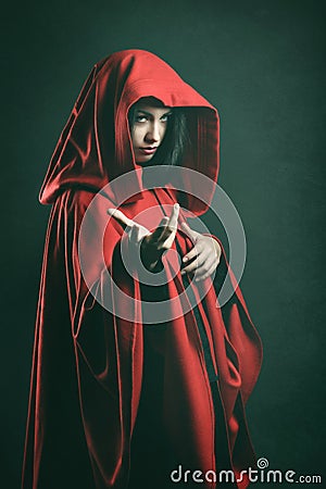 Dark portrait of a beautiful woman with red cloak Stock Photo