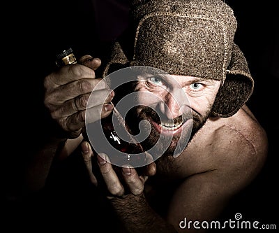 Dark portrait of scary evil sinister bearded man with smirk, holding a bottle of cognac. strange Russian man with a Stock Photo