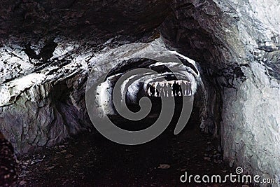 Dark and scary caves with a long tunnel Stock Photo