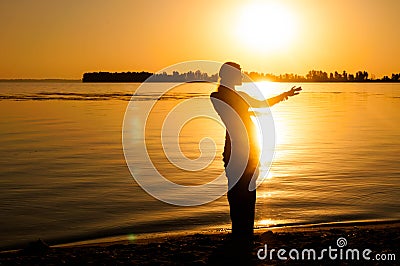 Silhouette of woman dancing tradition trible oriental near big river coast at dawn Stock Photo