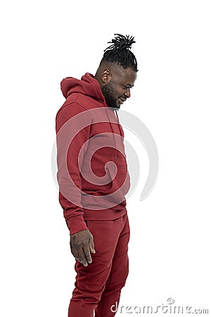 Dark skinned African man with pigtails in a ponytail and beard wearing burgundy tracksuit walking isolated Stock Photo