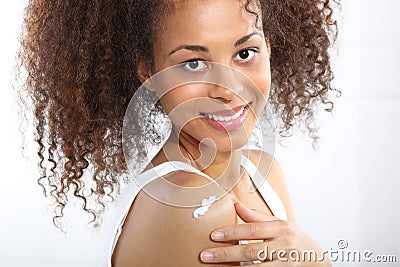 Dark skinned teen smiles rubbing cream Stock Photo