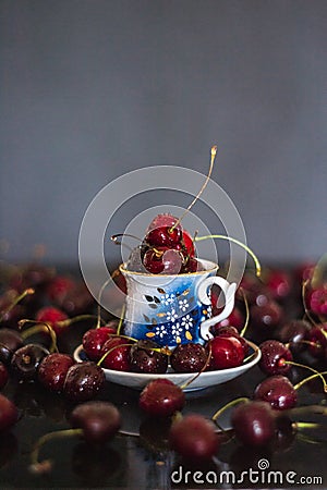 Dark stillife with porcelain cup of fresh cherries Stock Photo