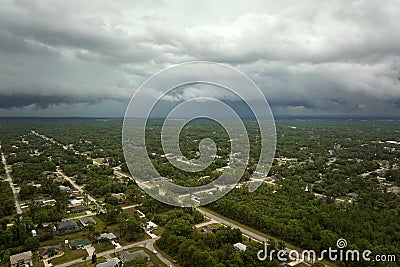 Dark stormy clouds forming on gloomy sky before heavy rainfall over suburban town area Stock Photo