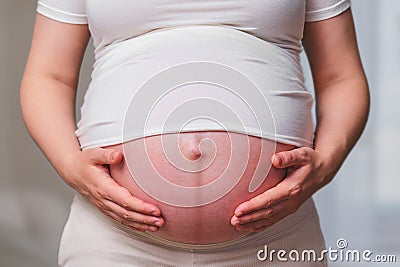 Dark stripe on the belly of a pregnant woman, home living room Stock Photo