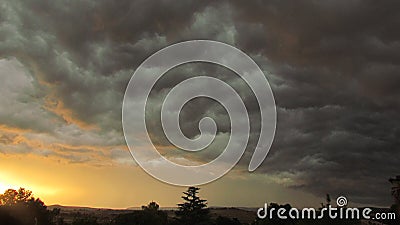 Dark thunderclouds underlit by set sun Stock Photo