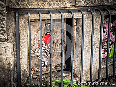 Dark window to the cellar with a scary clown pic on it. Editorial Stock Photo