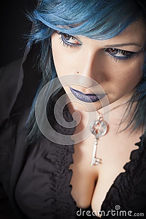 Dark woman with blue hair and lipstick. Key pendant. Dark girl Stock Photo