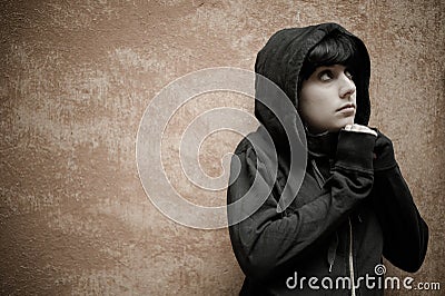 Dark young woman sad standing near urban wall portrait Stock Photo