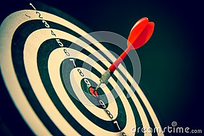 Dart hits center Bullseye is a target and goal of business, vintage style Stock Photo