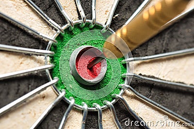 A dart hits the center of the darts board also known as Stock Photo