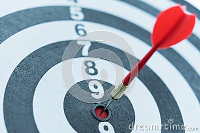 Dart target arrow hitting on bullseye with sun light Stock Photo