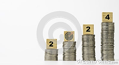2024 with dartboard arrow on coins stacking of white background for setup enhance financial objective target and business profit Stock Photo