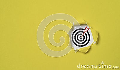 Dartboard with arrow inside of yellow punched paper for setup business objective target and goal concept Stock Photo