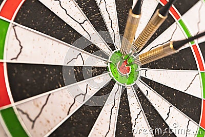Darts arrows in the target center. Dart in bulls eye of dartboard Stock Photo