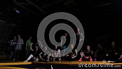 Das Kleinkind, das leichte Schläge auf Trampoline vor dem Zujubeln von jungen Leuten macht, drängen sich stock footage Das Kleinkind, das leichte Schläge auf Trampoline vor dem Zujubeln von jungen Leuten macht, drängen sich stock footage
