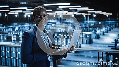 Data Center: Female Programmer Using Laptop Computer, Smiling and Looking at Camera. In Cloud Stock Photo