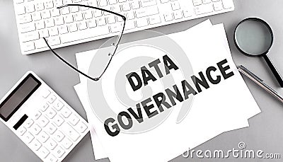 DATA GOVERNANCE text on paper with keyboard, calculator on grey background Stock Photo