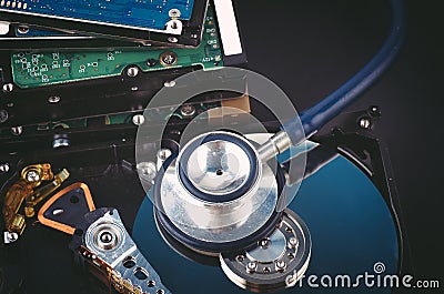 Stethoscope on dusty dismantle hard disk over dark background Stock Photo