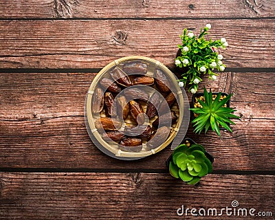 Dates or kurma on a wooden table with flower pot Stock Photo