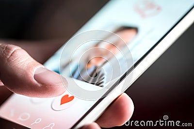 Dating app or site in mobile phone screen. Man swiping and liking profiles. Stock Photo