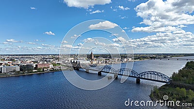 Daugava River Railway Bridge electric train crossing transshipment cargo docks wharf Riga pier aerial top view famous Stock Photo