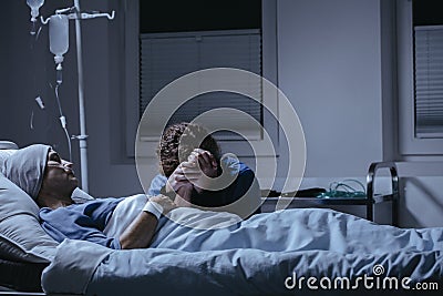 Daughter crying at bed with dying mother with cancer in the hospital Stock Photo