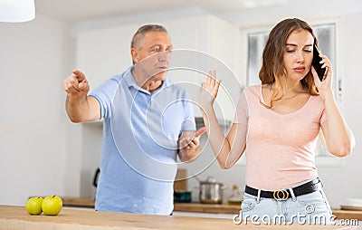 Daughter father scolding and yelling at her in home kitchen Stock Photo