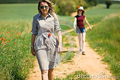 Daughter is following her mother on cart road Stock Photo