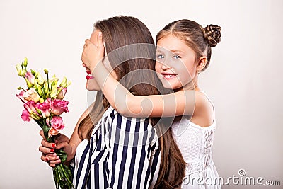 Daughter gives flowers to her mother on her mother`s day Stock Photo