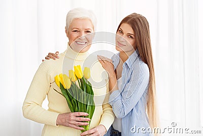 Daughter giving her mother bouquet of tulips Stock Photo