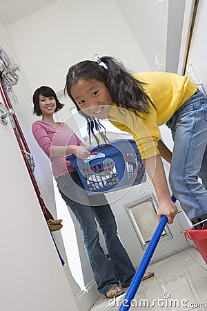 Daughter Helping Mother In Cleaning Floor Stock Photo