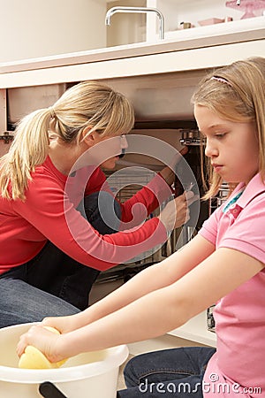 Daughter Helping Mother To Mop Up Leak Stock Photo