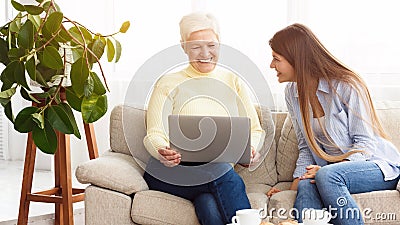 Daughter showing mother funny videos on laptop Stock Photo