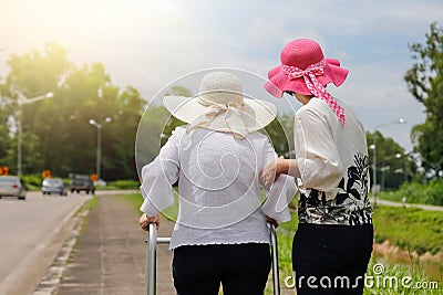 Daughter take care elderly woman walking on street Stock Photo