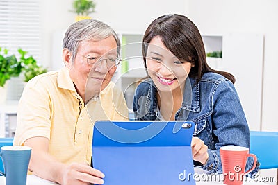 Daughter teach father use tablet Stock Photo