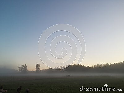 Dawn the beginning of a new day with a light morning fog on the field Stock Photo