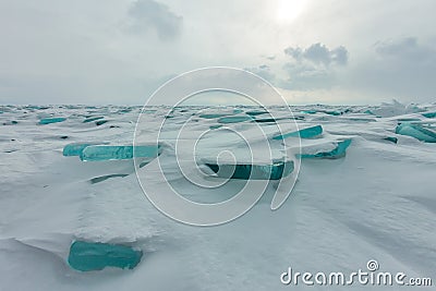 Dawn in the blue hummocks of ice lake baikal, in a snowy field in winter on a journey Stock Photo