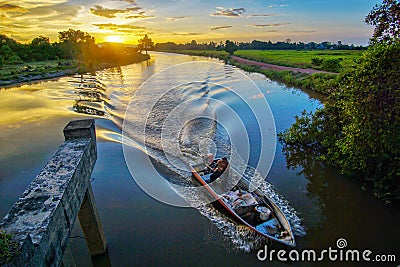 In the dawn , a fisherman going back home for his family . The boat is little bit blurry because of dark Stock Photo